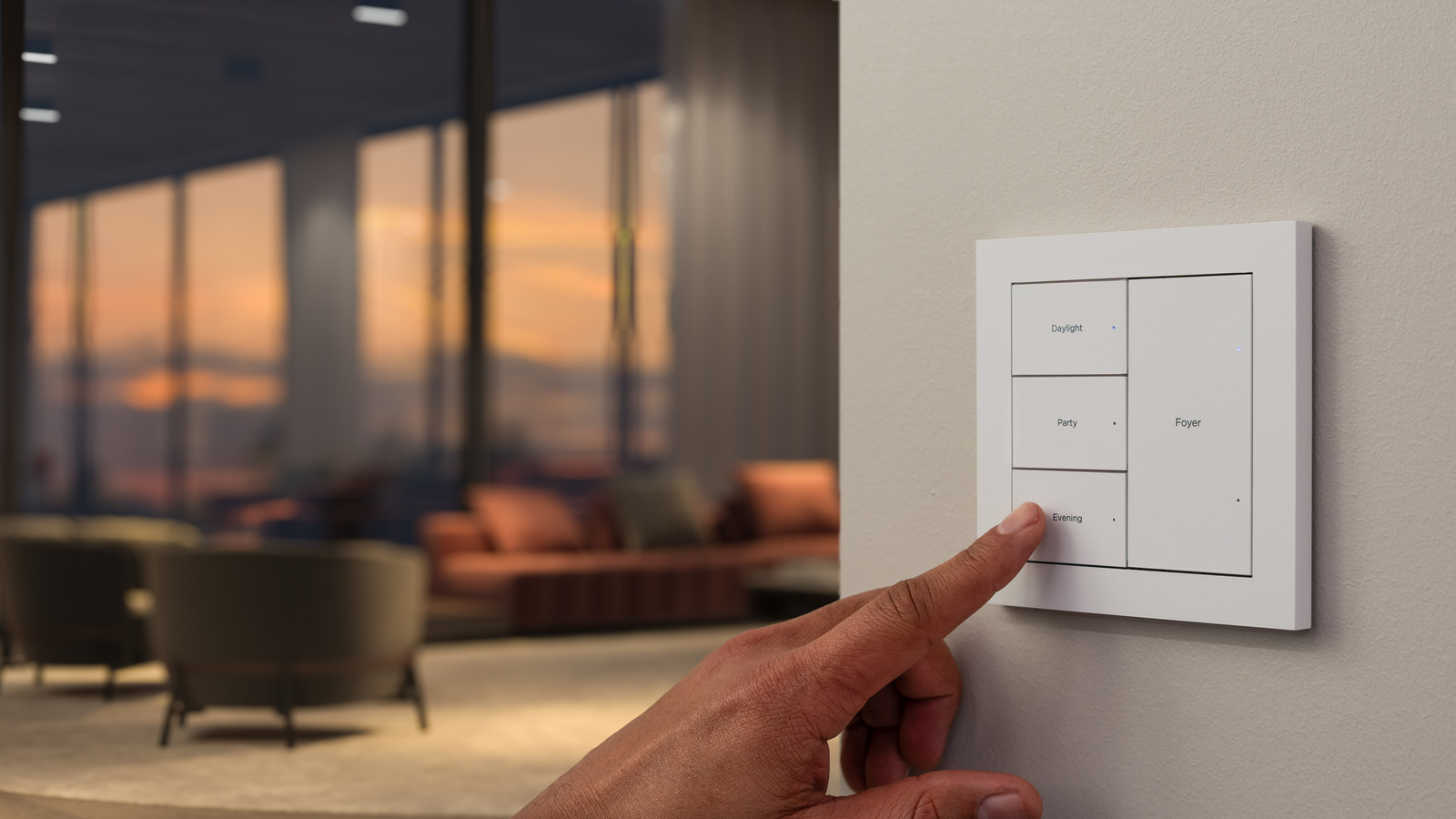A hand selects a Control4 keypad scene beside a softly lit living room