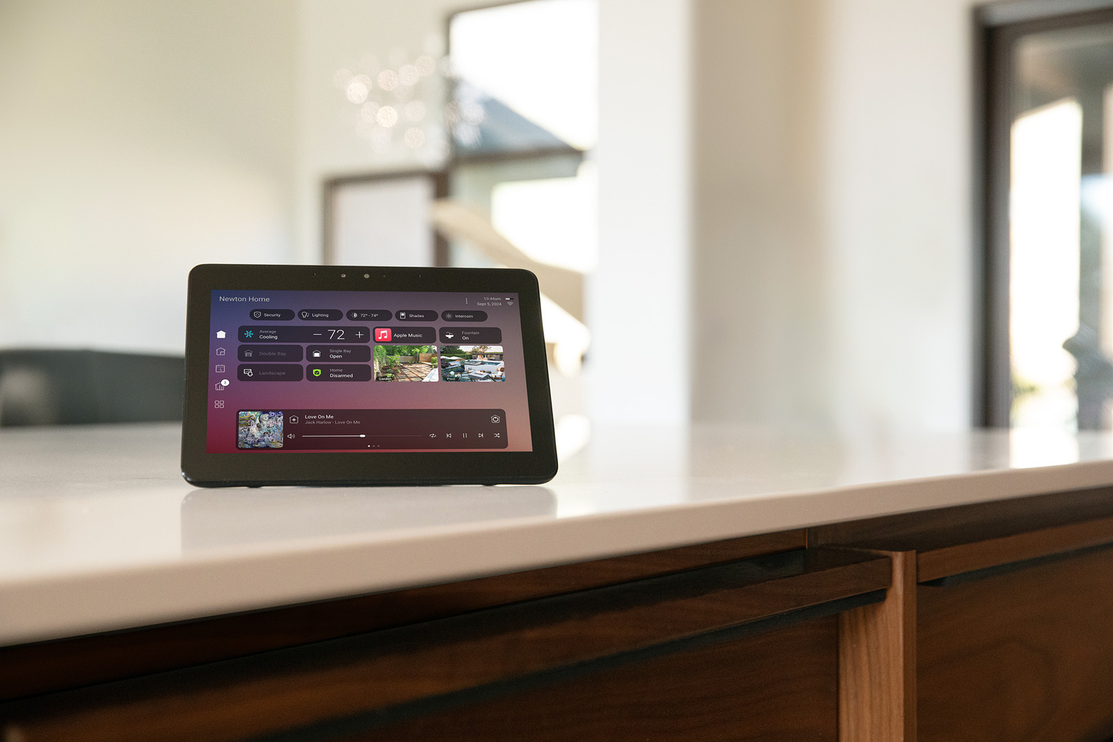 A Control4 touchscreen on a kitchen counter displaying room controls