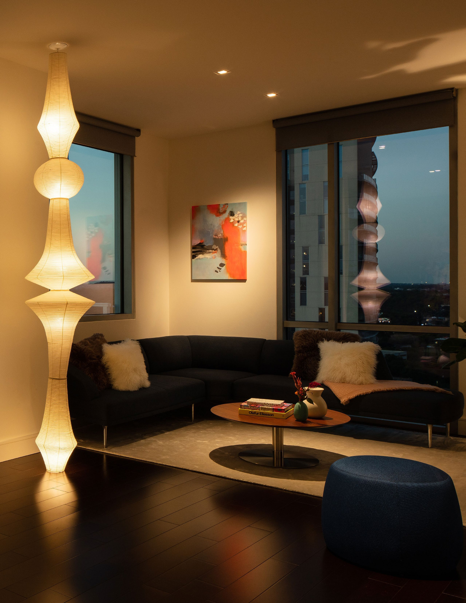 A Ketra-lit lounge with warm light on artwork, walls and seating