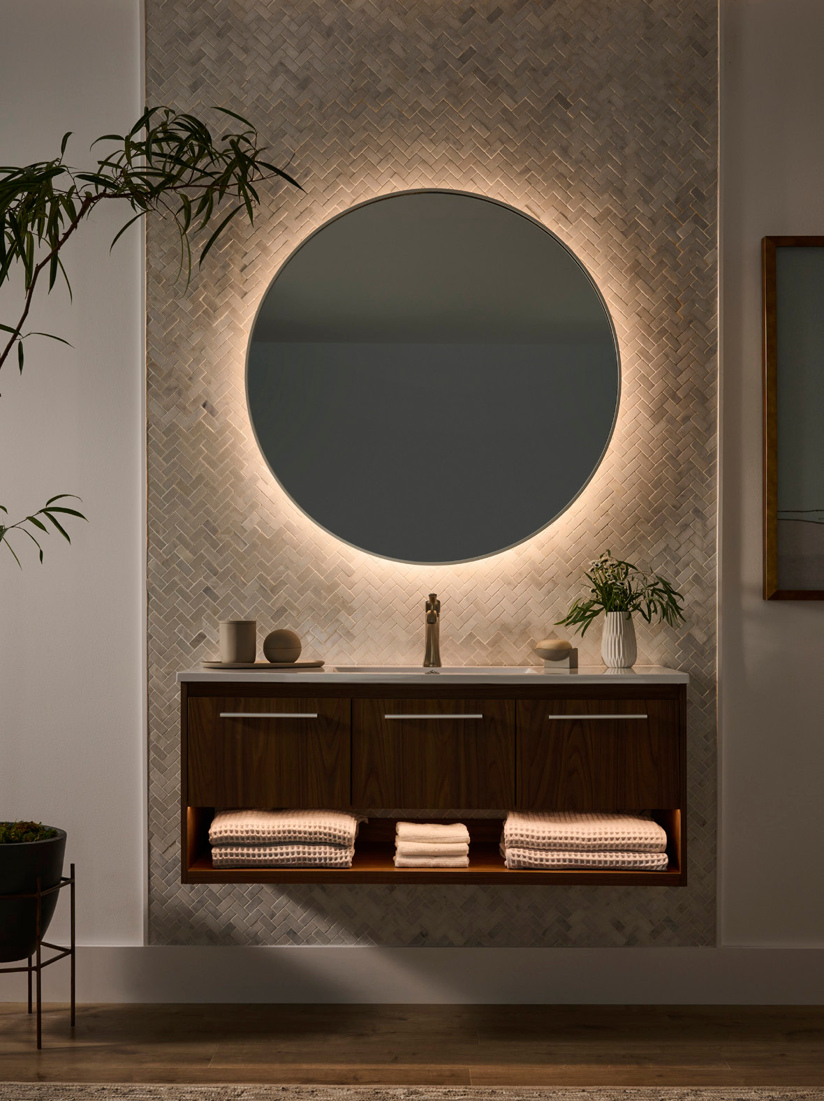 The same bathroom vanity and round mirror in a warmer white-light setting