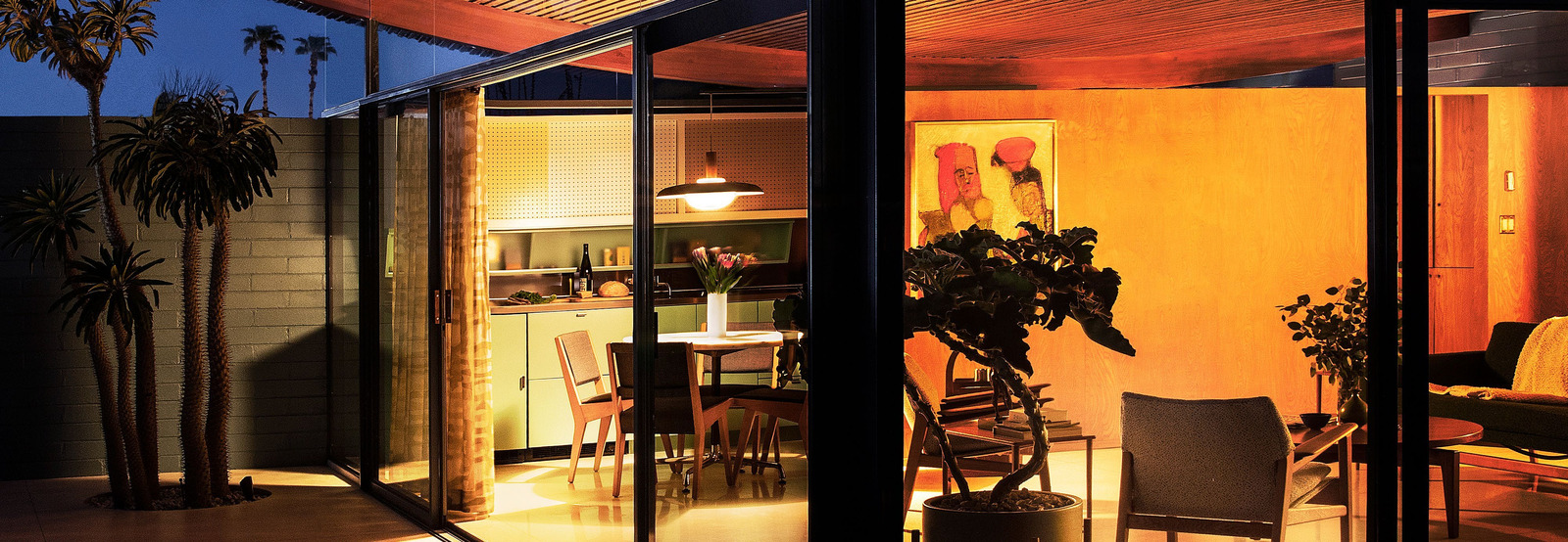 Warm light inside the glass-walled Wave House at dusk