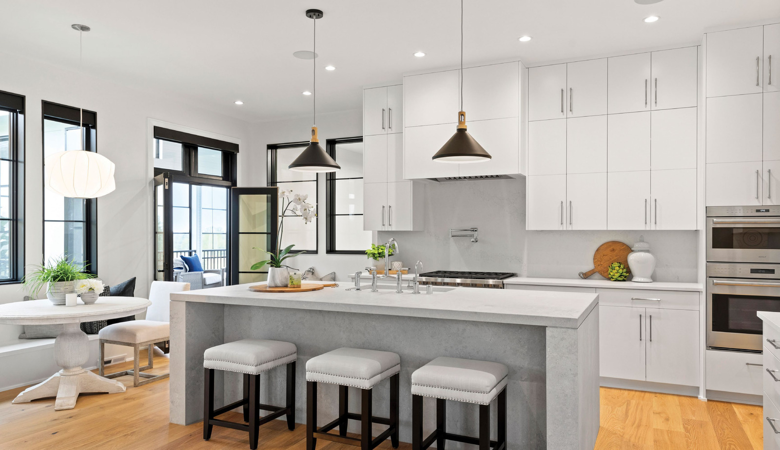 A bright kitchen with white cabinetry, pendant lights and a broad island