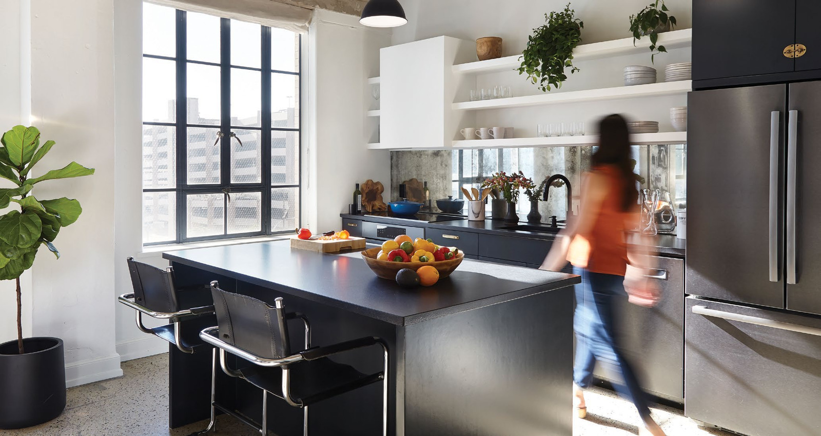 An Austin loft kitchen in a bright daytime setting with pendant lights over its island